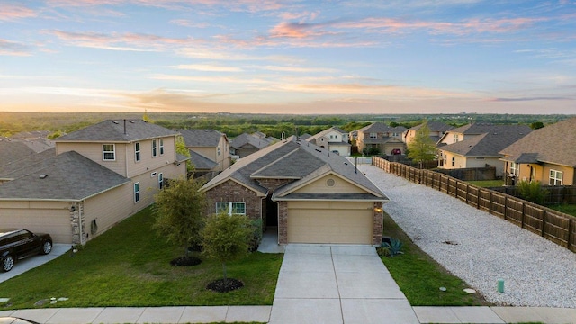 view of front of home featuring fence, a residential view, driveway, a front yard, and a garage