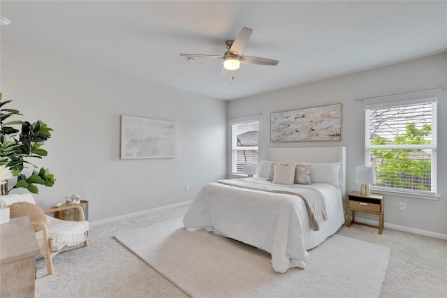bedroom featuring baseboards, ceiling fan, and light colored carpet