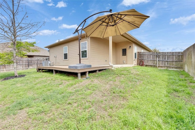 back of house featuring a lawn, central AC, a fenced backyard, and a deck