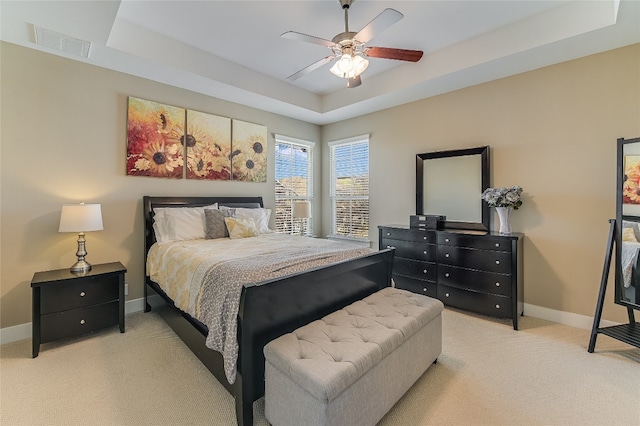 928 Sugaree Ave, Austin, TX 78757 - bedroom with baseboards, light colored carpet, a tray ceiling, and a ceiling fan