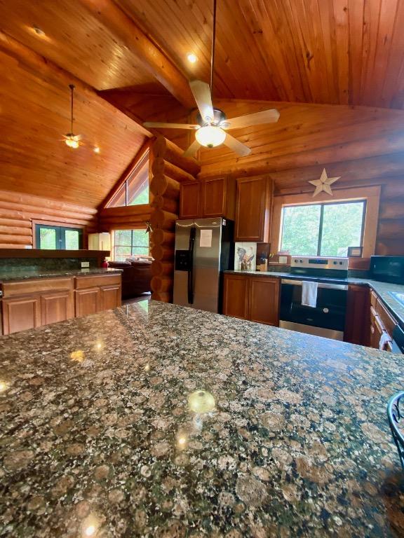 2550 Fm 2342 Hero'S Hideaway, Unit Heros Hideaway, Burnet, TX 78611 - kitchen featuring stainless steel appliances, wood ceiling, rustic walls, brown cabinetry, and dark stone counters