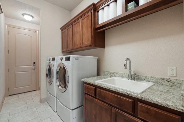 washroom featuring a sink, cabinet space, and separate washer and dryer