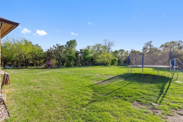view of yard with a trampoline and playground community