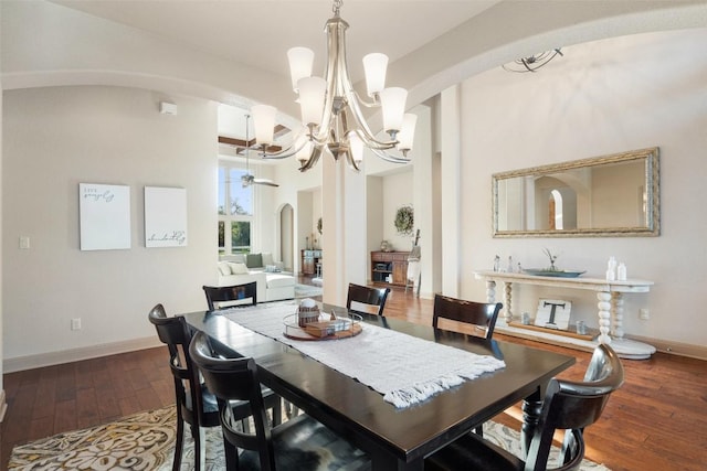 dining area featuring arched walkways, baseboards, ceiling fan with notable chandelier, and wood-type flooring