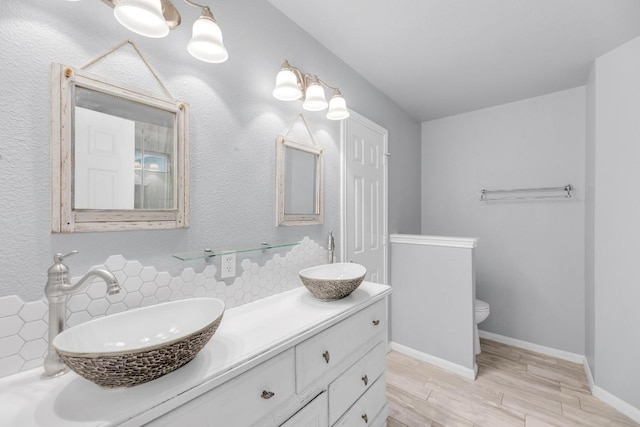 1708 Royal Ascot Dr, Pflugerville, TX 78660 - full bathroom featuring double vanity, backsplash, wood finished floors, and a sink