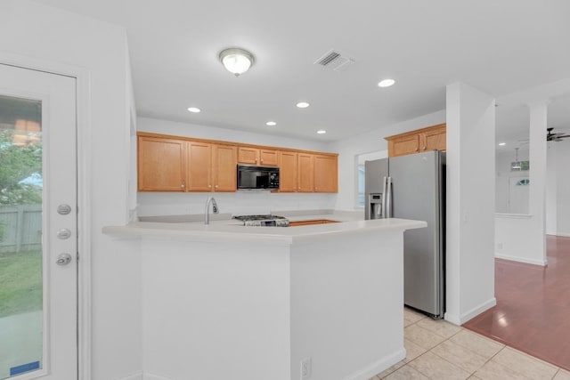 1708 Royal Ascot Dr, Pflugerville, TX 78660 - kitchen featuring light countertops, stainless steel refrigerator with ice dispenser, visible vents, a peninsula, and black microwave