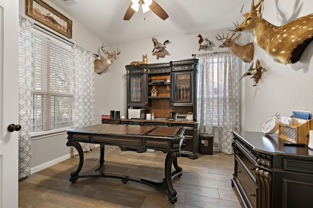 office featuring a ceiling fan, baseboards, and wood finished floors