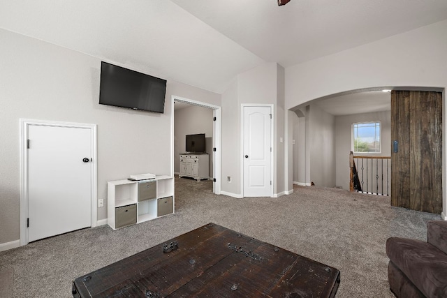 unfurnished living room with carpet floors, arched walkways, baseboards, and lofted ceiling