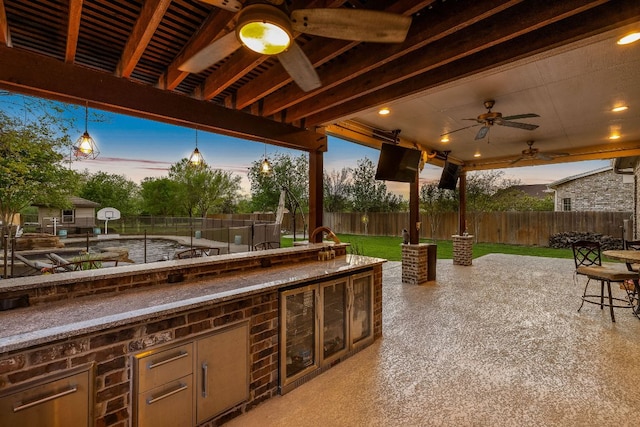 view of patio featuring fence, area for grilling, and a ceiling fan