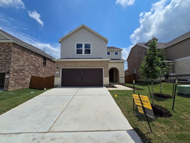 traditional home featuring fence, a garage, a front yard, central air condition unit, and driveway