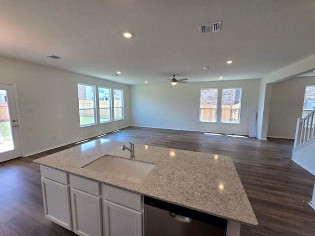 kitchen featuring visible vents, a sink, open floor plan, and stainless steel dishwasher