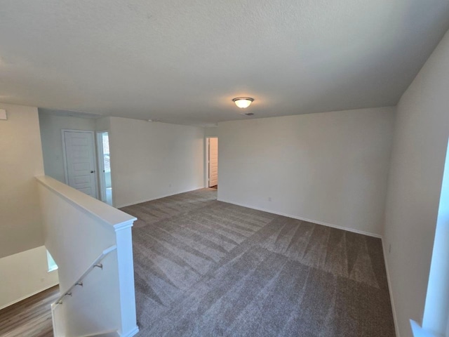 carpeted empty room featuring baseboards