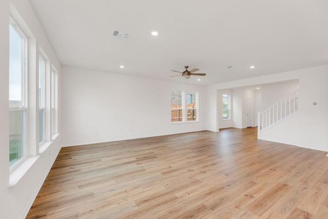 4915 Mozzafiato Ln, Round Rock, TX 78665 - unfurnished living room featuring light wood finished floors, recessed lighting, a ceiling fan, and stairs