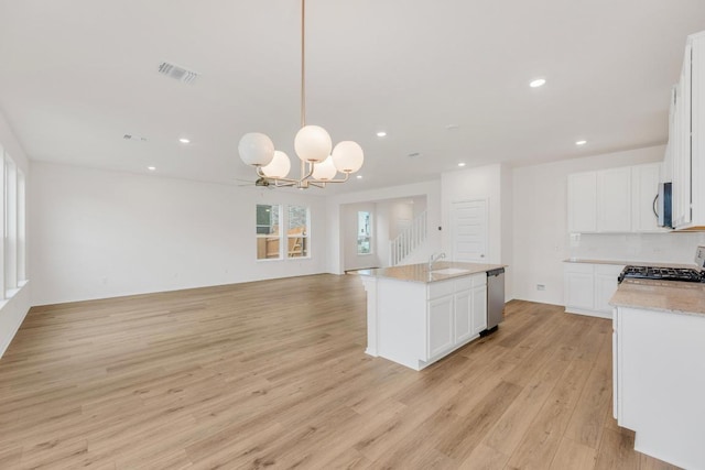 4915 Mozzafiato Ln, Round Rock, TX 78665 - kitchen with stainless steel appliances, open floor plan, a chandelier, light wood-type flooring, and recessed lighting
