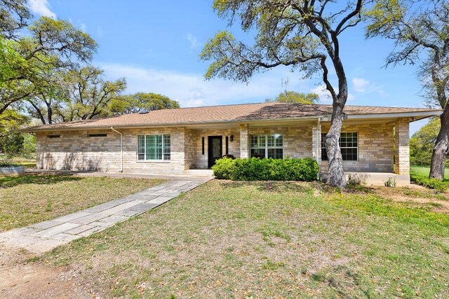 ranch-style house with stone siding and a front yard