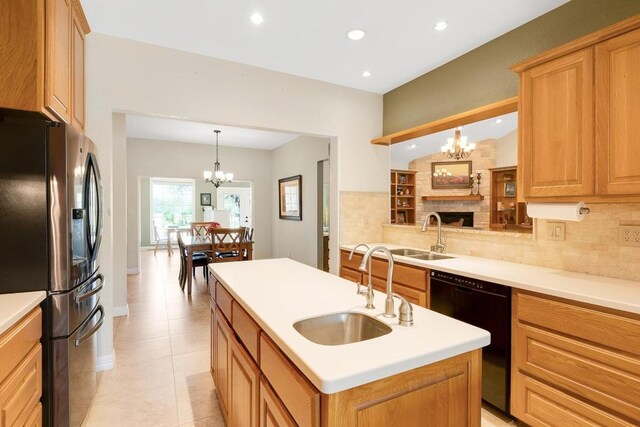 kitchen with a sink, black appliances, and a chandelier