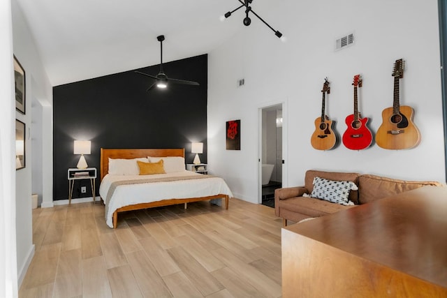 10100 Dobbin Dr, Austin, TX 78748 - bedroom featuring high vaulted ceiling, baseboards, light wood-style floors, and an accent wall