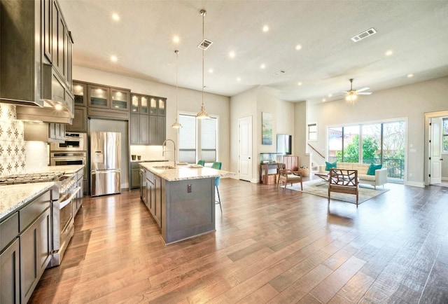 12113 Beautybrush Dr, Austin, TX 78738 - kitchen featuring stainless steel appliances, open floor plan, recessed lighting, a kitchen island with sink, and a ceiling fan