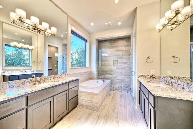 12113 Beautybrush Dr, Austin, TX 78738 - bathroom featuring a chandelier, a shower stall, a garden tub, two vanities, and recessed lighting