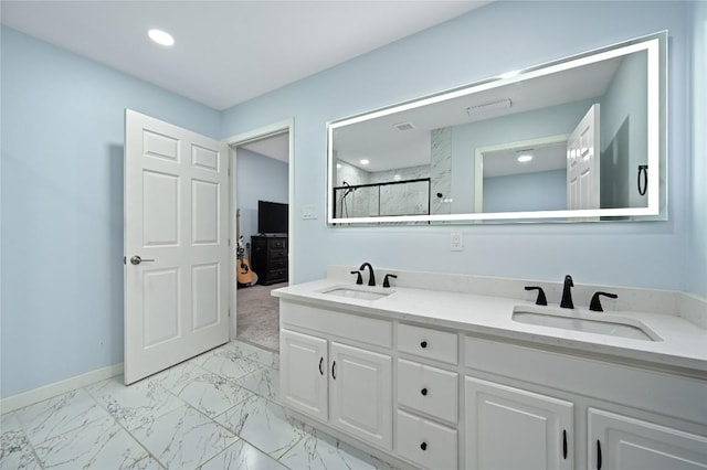 ensuite bathroom with double vanity, a sink, marble finish floor, and a shower stall