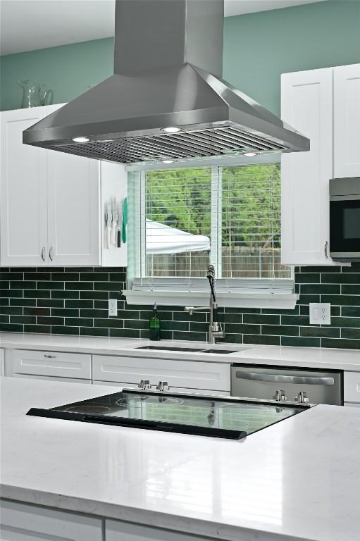 kitchen with light countertops, stainless steel appliances, and island range hood