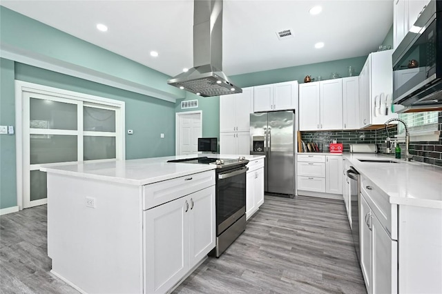 kitchen featuring a sink, a center island, stainless steel appliances, island range hood, and visible vents