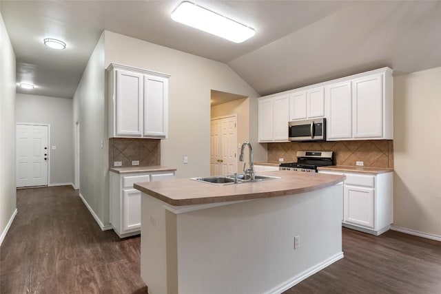 4009 Veiled Falls Dr, Pflugerville, TX 78660 - kitchen with stainless steel appliances, dark wood-type flooring, decorative backsplash, white cabinets, and vaulted ceiling