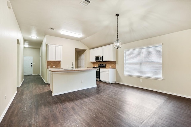 4009 Veiled Falls Dr, Pflugerville, TX 78660 - kitchen with stainless steel appliances, backsplash, dark wood-style flooring, white cabinetry, and vaulted ceiling