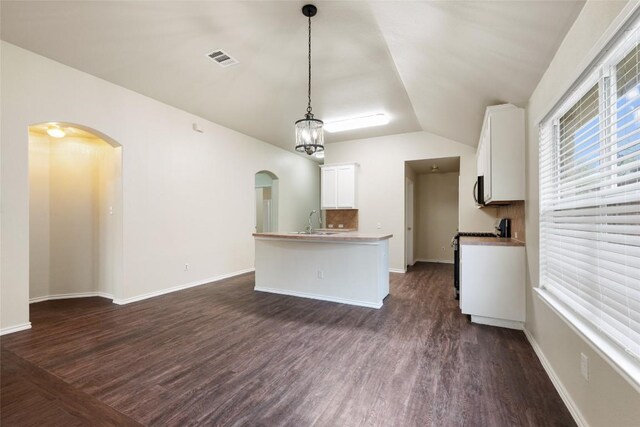 4009 Veiled Falls Dr, Pflugerville, TX 78660 - kitchen with range, visible vents, dark wood finished floors, arched walkways, and vaulted ceiling