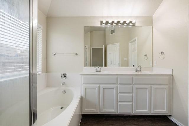 4009 Veiled Falls Dr, Pflugerville, TX 78660 - full bathroom with double vanity, a bath, and wood finished floors