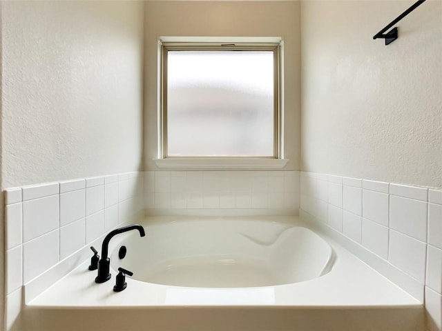 137 Periwinkle Ln, Bastrop, TX 78602 - bathroom with a textured wall and a bath