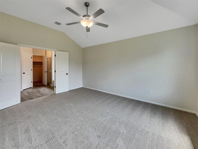 137 Periwinkle Ln, Bastrop, TX 78602 - unfurnished bedroom featuring vaulted ceiling, carpet flooring, a walk in closet, and a ceiling fan