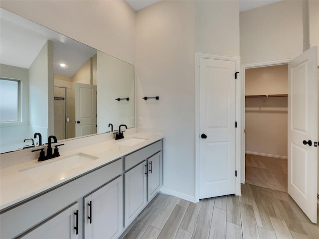 137 Periwinkle Ln, Bastrop, TX 78602 - full bathroom with double vanity, a stall shower, a walk in closet, and recessed lighting