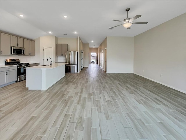 137 Periwinkle Ln, Bastrop, TX 78602 - kitchen with stainless steel appliances, open floor plan, light wood finished floors, vaulted ceiling, and gray cabinets