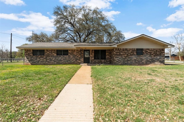 ranch-style home with a front lawn, fence, and brick siding