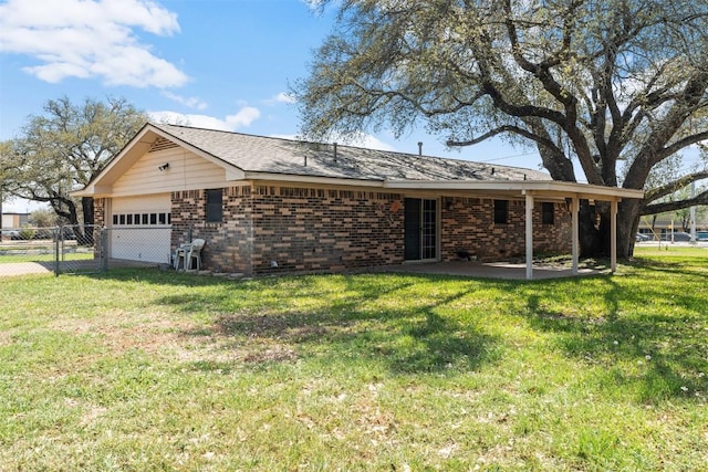 view of front of house with a patio area, an attached garage, fence, brick siding, and a front lawn