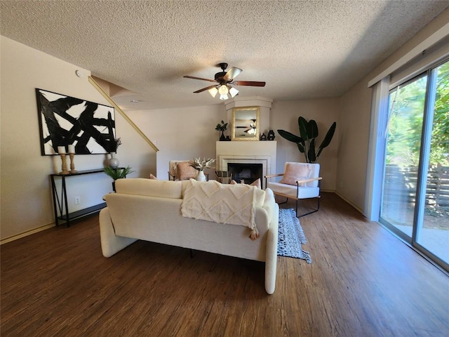 2516 Glen Field Dr, Cedar Park, TX 78613 - living area with wood finished floors, a textured ceiling, a fireplace, and a ceiling fan
