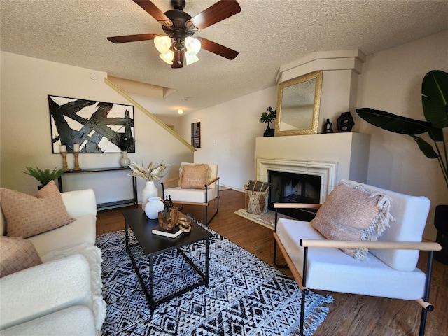 2516 Glen Field Dr, Cedar Park, TX 78613 - living area with wood finished floors, a textured ceiling, ceiling fan, and a fireplace with raised hearth