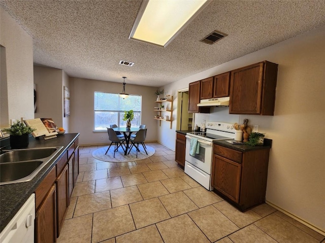 2516 Glen Field Dr, Cedar Park, TX 78613 - kitchen featuring white appliances, dark countertops, under cabinet range hood, hanging light fixtures, and light tile patterned flooring
