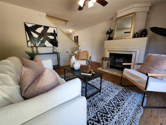 2516 Glen Field Dr, Cedar Park, TX 78613 - living room featuring a ceiling fan, a textured ceiling, wood finished floors, and a tile fireplace