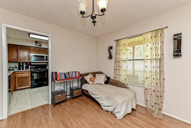 1306 Daytona Dr, Austin, TX 78733 - bedroom with light wood finished floors, a chandelier, and a textured ceiling