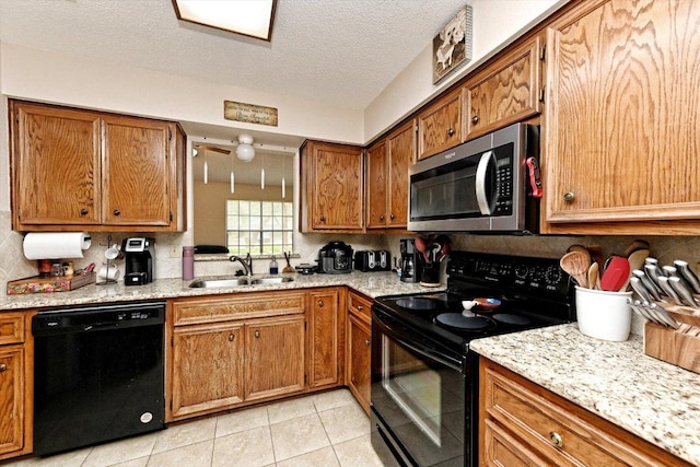 1306 Daytona Dr, Austin, TX 78733 - kitchen with black appliances, brown cabinets, backsplash, light tile patterned floors, and a textured ceiling
