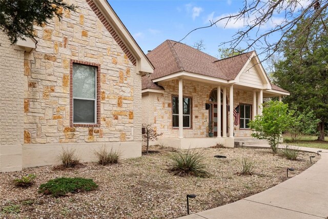 330 Arbors Cir, Elgin, TX 78621 - view of front of house with stone siding, a porch, and a shingled roof