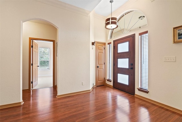 330 Arbors Cir, Elgin, TX 78621 - entryway featuring arched walkways, wood finished floors, ornamental molding, and baseboards