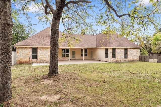 330 Arbors Cir, Elgin, TX 78621 - back of property featuring stone siding, a patio, and roof with shingles