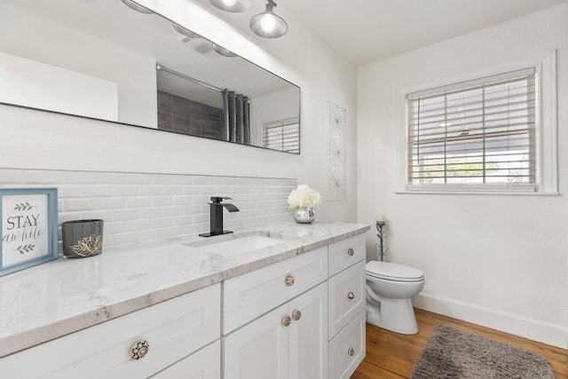 904 Fisher St, Taylor, TX 76574 - full bathroom with vanity, backsplash, wood finished floors, and a shower with curtain