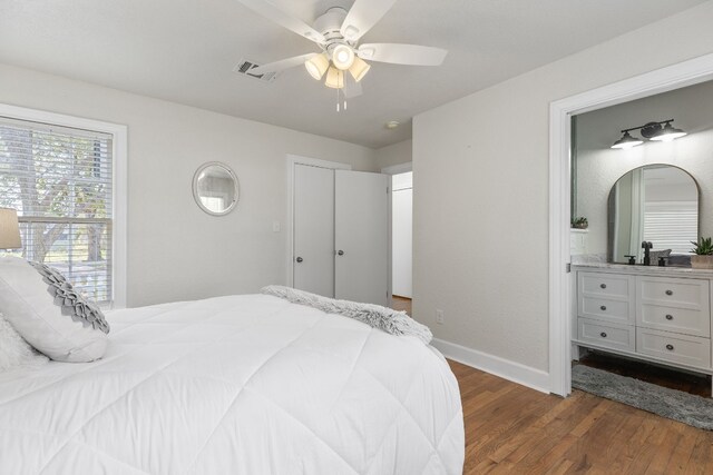 904 Fisher St, Taylor, TX 76574 - bedroom featuring dark wood finished floors, ceiling fan, and ensuite bath