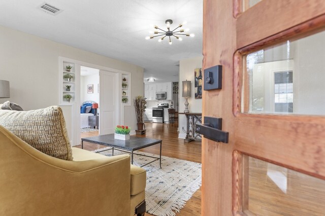 904 Fisher St, Taylor, TX 76574 - living area with a chandelier, wood finished floors, and built in shelves