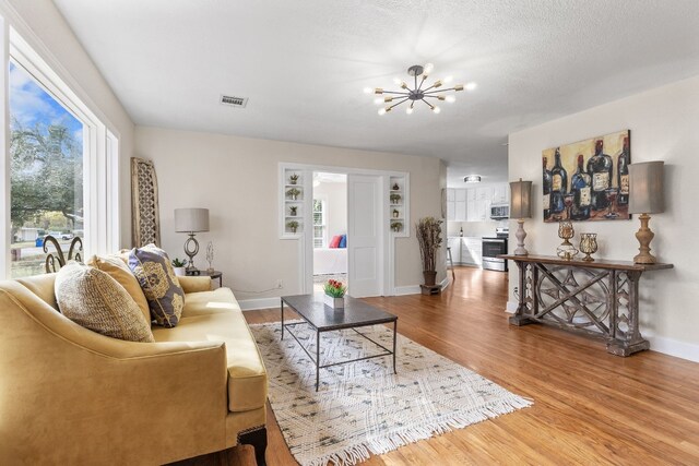 904 Fisher St, Taylor, TX 76574 - living room featuring a chandelier and wood finished floors