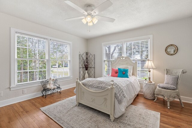 904 Fisher St, Taylor, TX 76574 - bedroom with multiple windows, wood finished floors, ceiling fan, and a textured ceiling